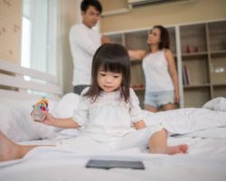 little-girl-sitting-with-her-parents-bed-looking-serious_1150-4933-300×200-1